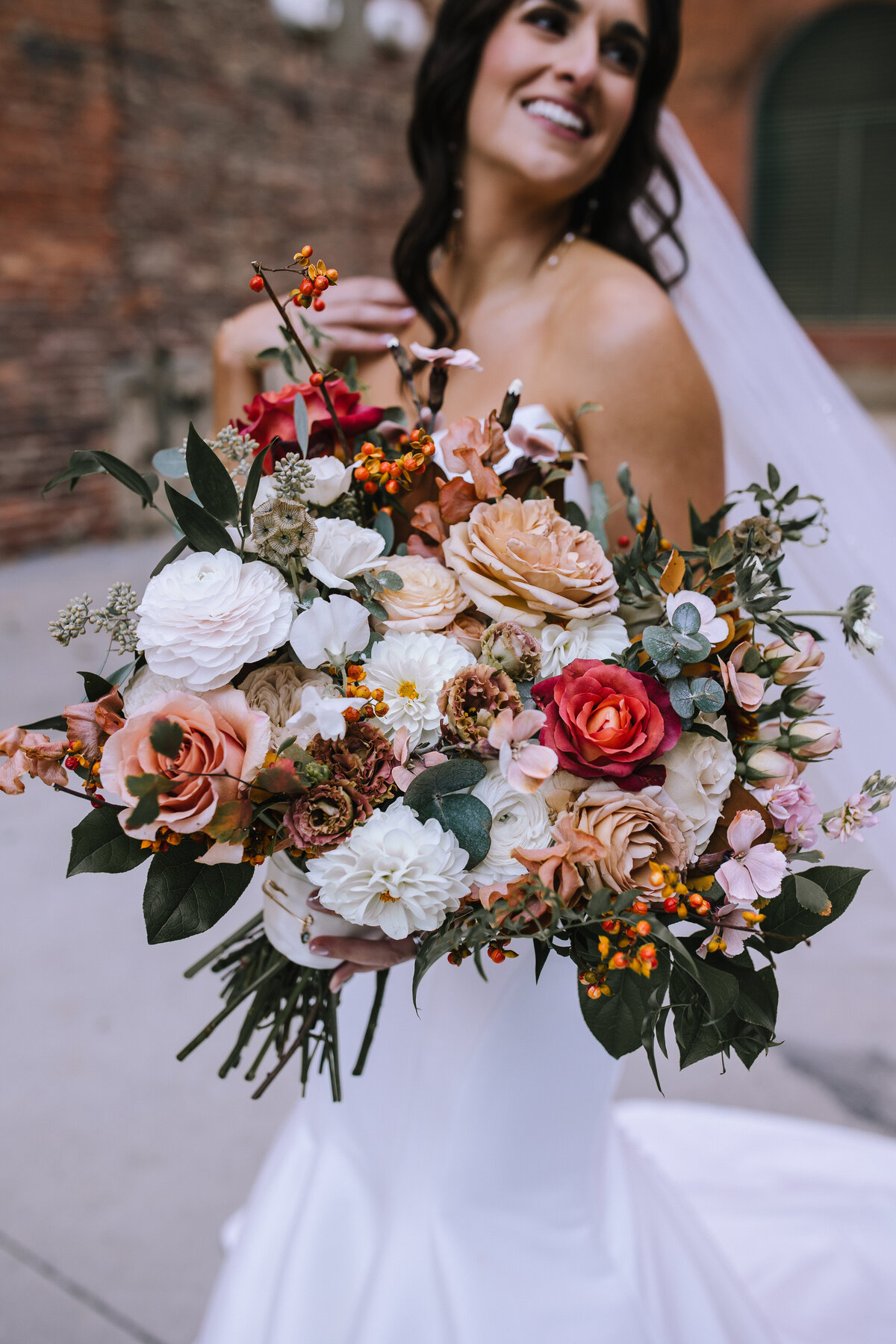 Bride holding a bouquet from The Farmer's Daughter Flowers outside of Heinz History Center.