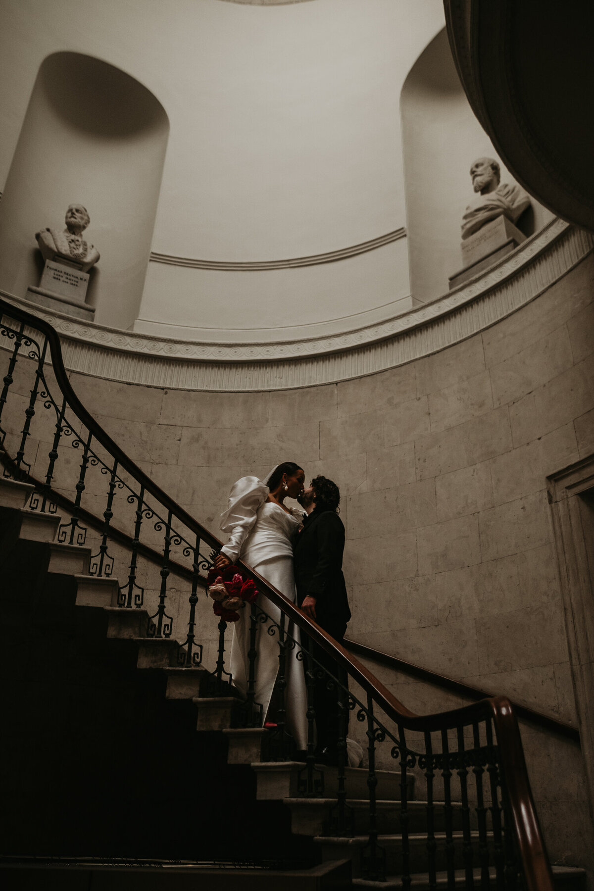 Couple kiss on the stairs at their wedding in Dublin City Hall.