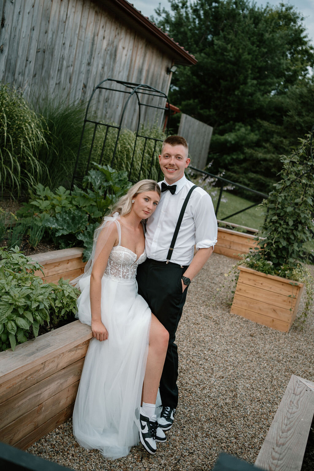 bride and groom in the willowbrook wedding venue herb garden wearing matching Nike tennis shoes.