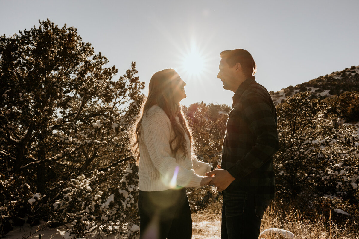 couple holding hands and laughing  with a sun flare