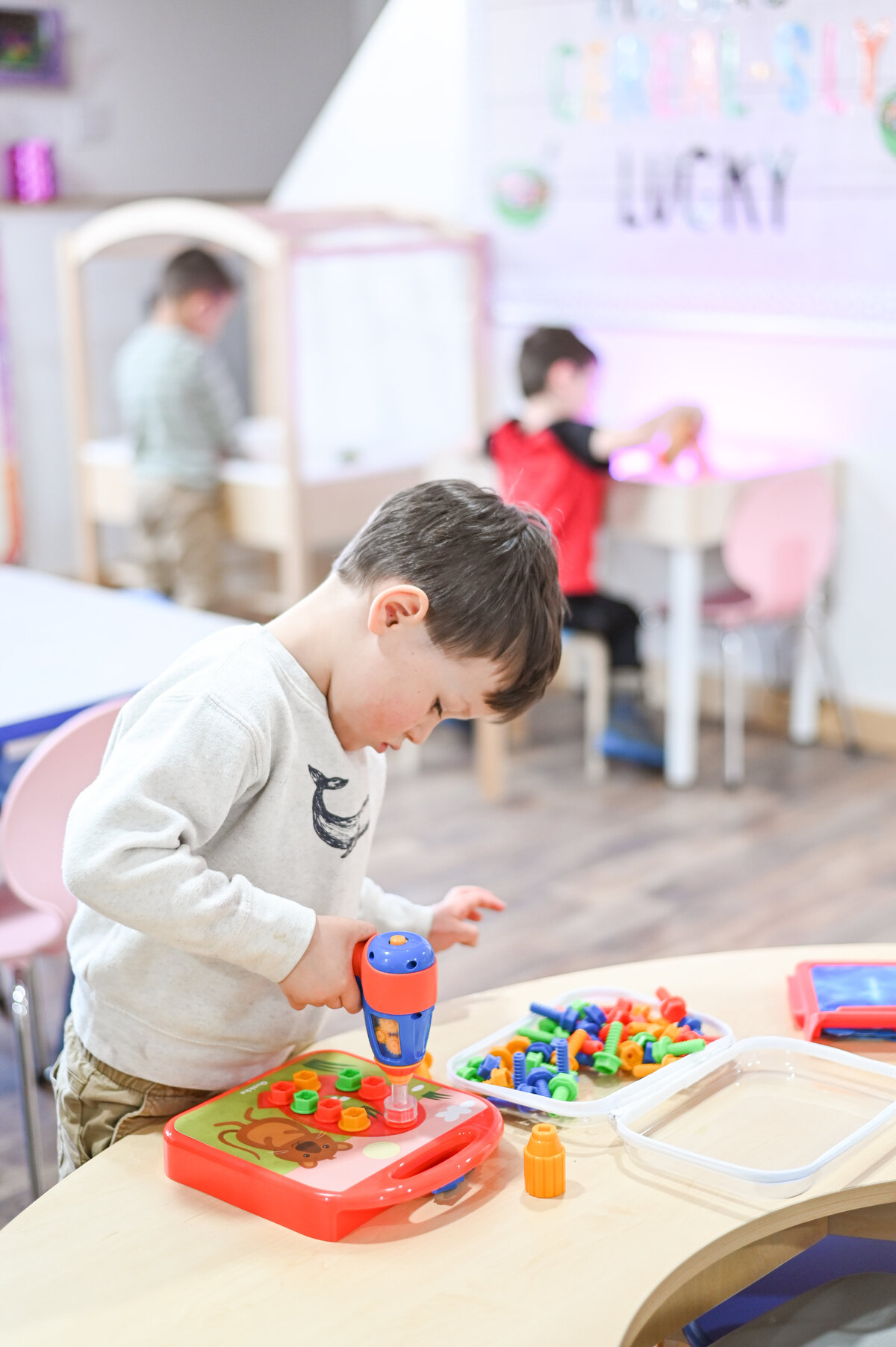 Student using fine motor station at House of Parker Preschool Gorham Maine where every detail is thoughtfully designed to create a warm, welcoming space for children to explore, learn, and grow with comfort and confidence.