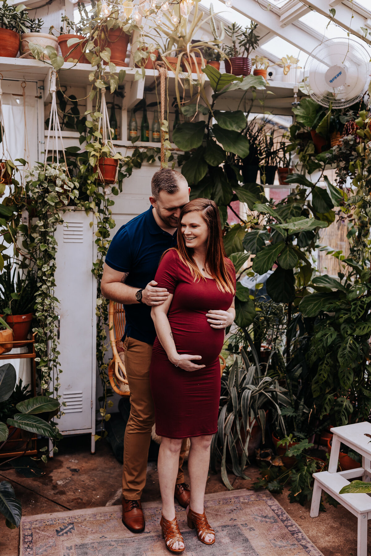 Nashville newborn photographer captures couple hugging during greenhouse pregnancy photos