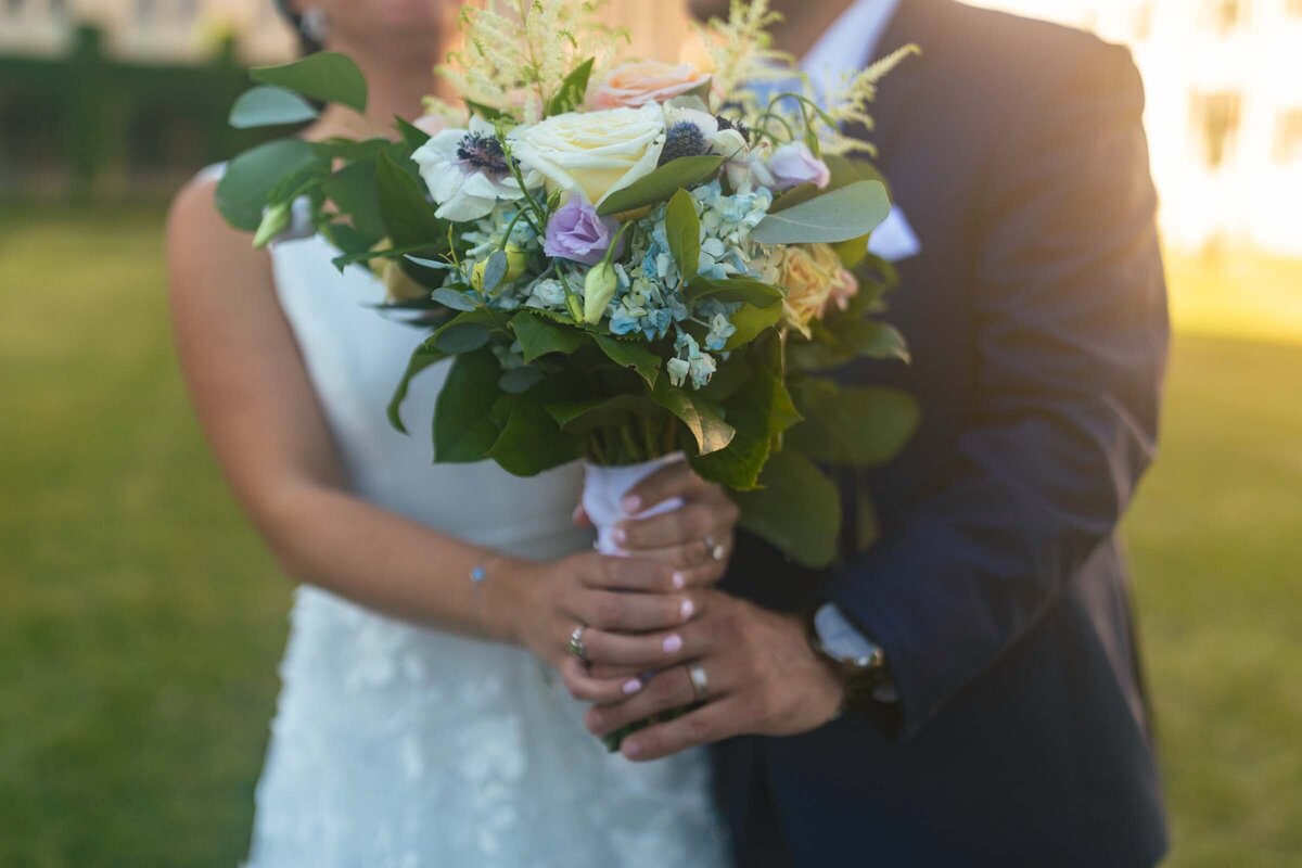 bride-groom-hug-bouquet-wedding