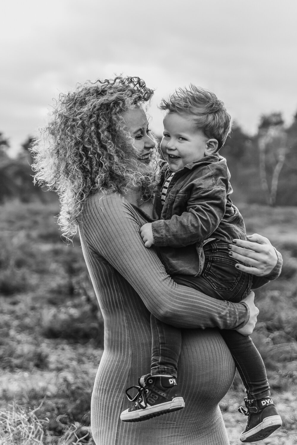 Vrouw zwanger met zoon lachend