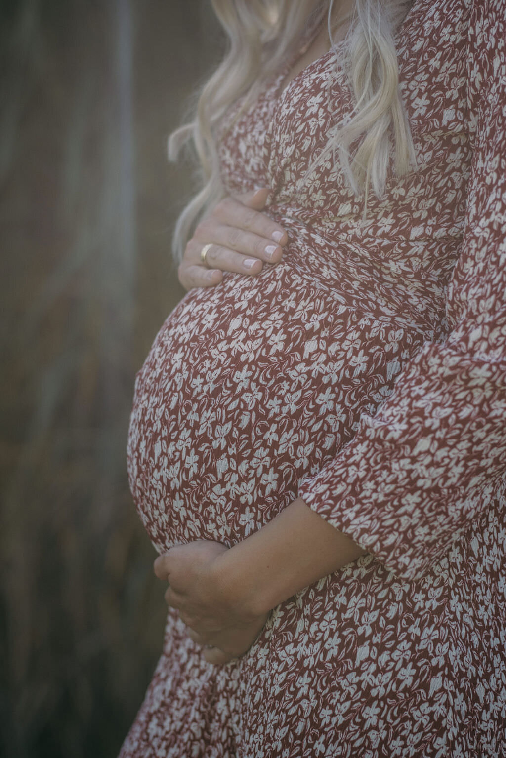 Closeup of a baby bump in a flower-dress.