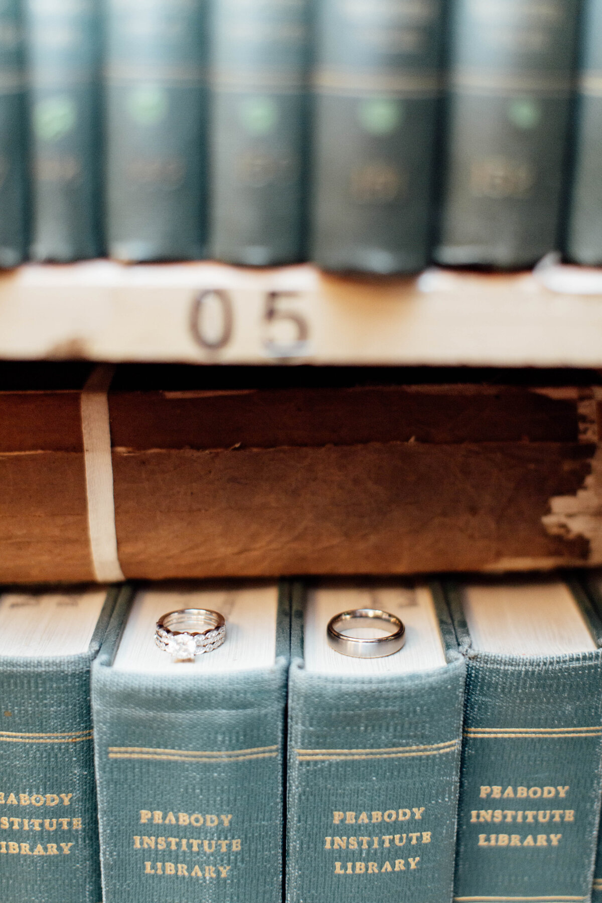 Wedding bands sitting on books in a library.