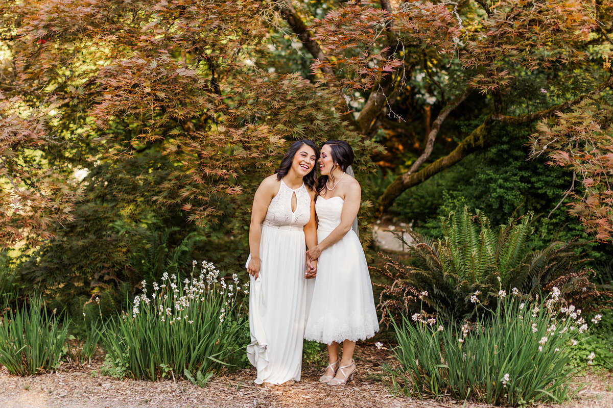 Two-brides-celebrate-their-LGBTQ-wedding-at-Seattle-Arboretum-surrounded-by-trees-photo-by-Joanna-Monger-Photography