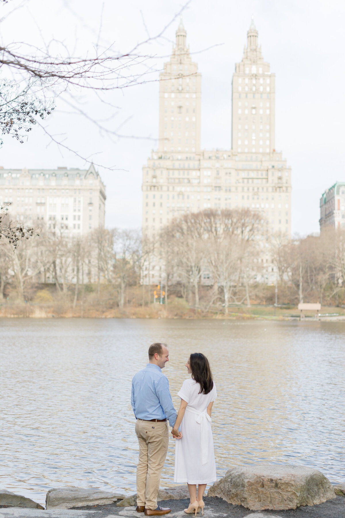 couple looking over water at New York City maternity photography session