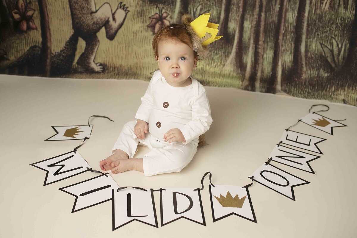 Redhead birthday boy in a Where the Wild Things Are themed outfit, surrounded by whimsical props from the book