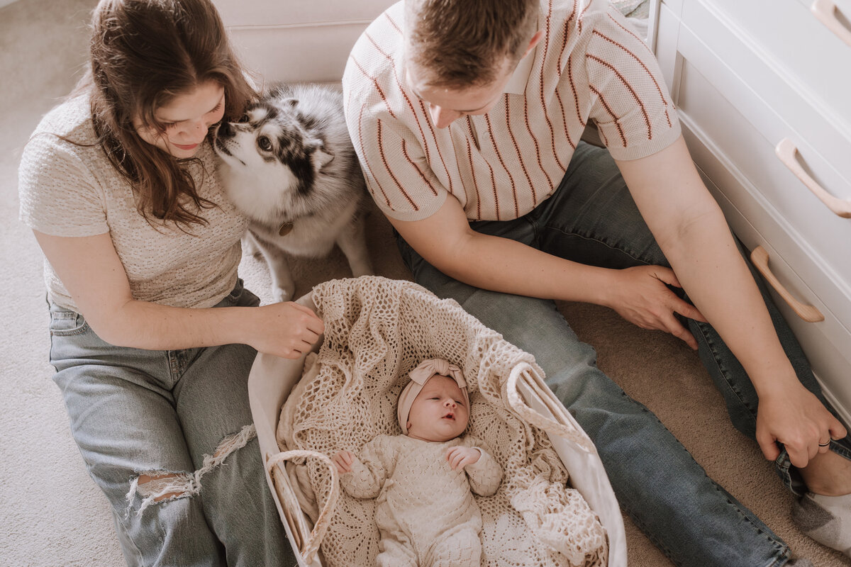 baby in basket with parents looking in