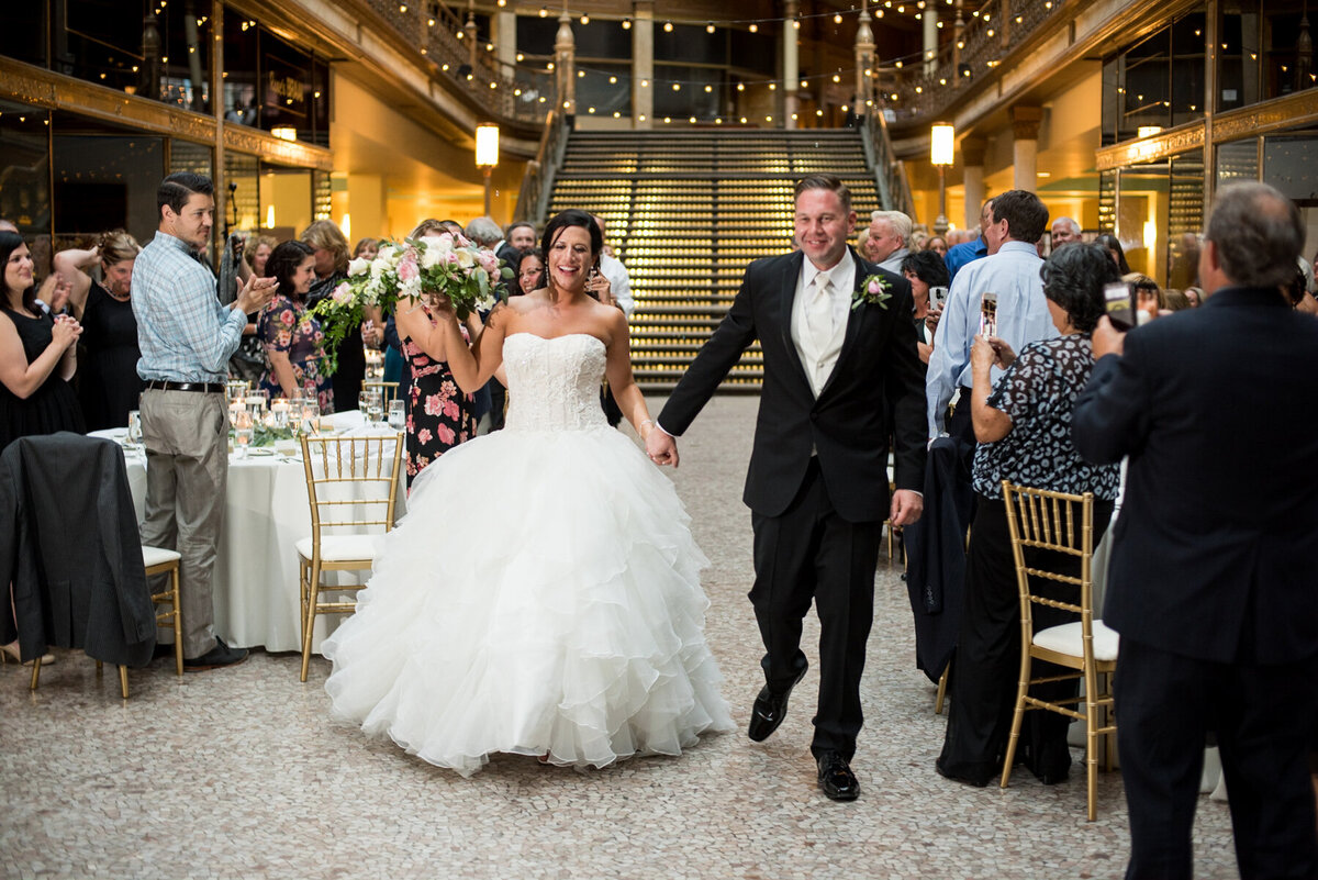 Happy Bride and Groom enter wedding reception at cleveland arcade