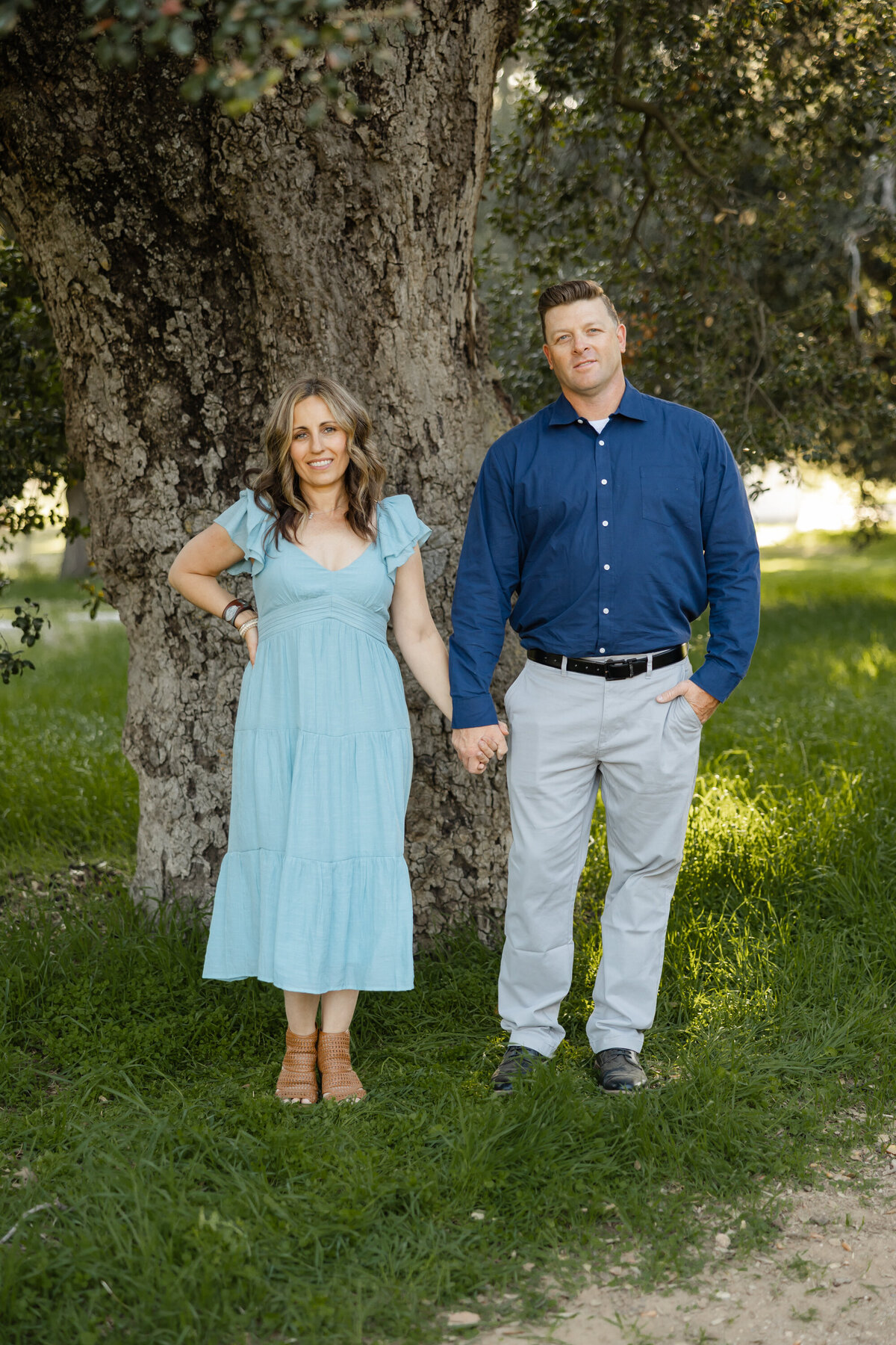 Mother and father standing together in coordinated blue outfits outdoors. Photographed by Yucaipa family photographer Kaitlyn Dawn Photography.