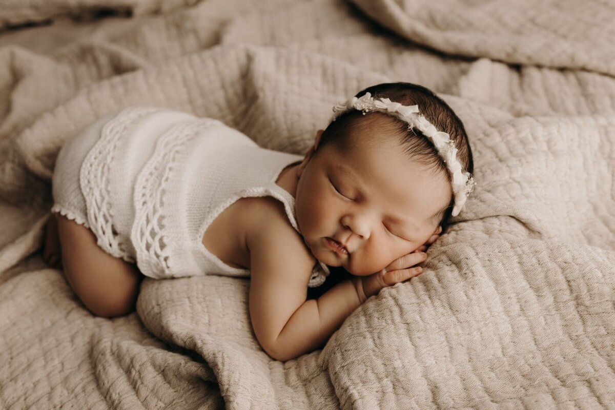 Beautiful sleeping newborn baby girl with a delicate headband during a Mullingar photography session