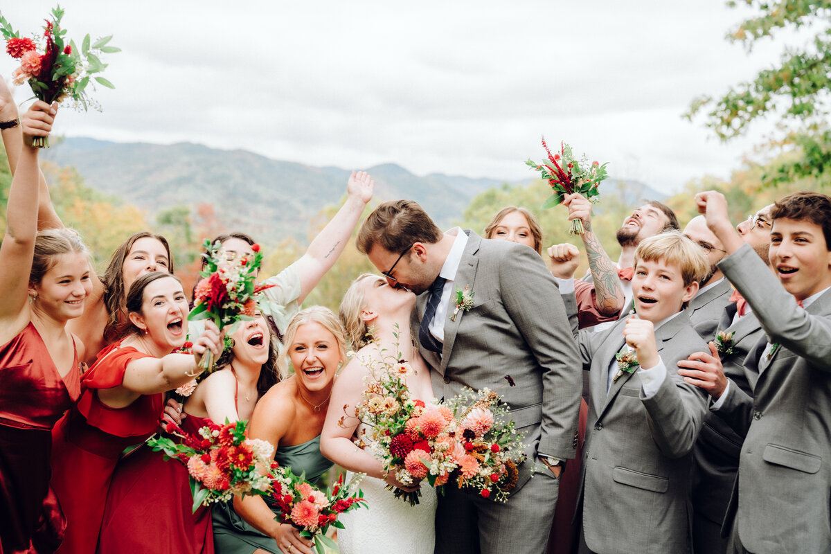 Wedding party celebrates as bride and groom kiss, taken by Asheville Wedding Photographer Simon Anthony Photography