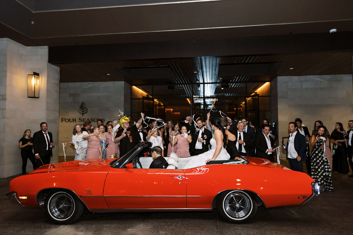 bride and groom leaving in classic car