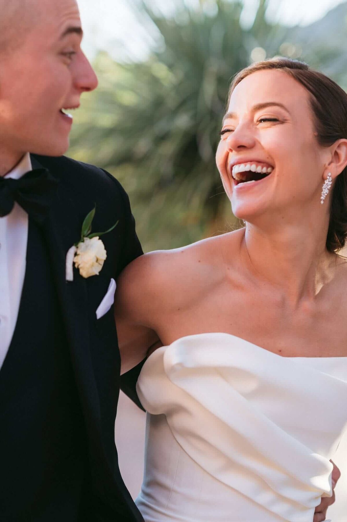 Bride laughing joyfully with her groom during their Four Seasons Scottsdale wedding, captured by a Phoenix wedding photographer.