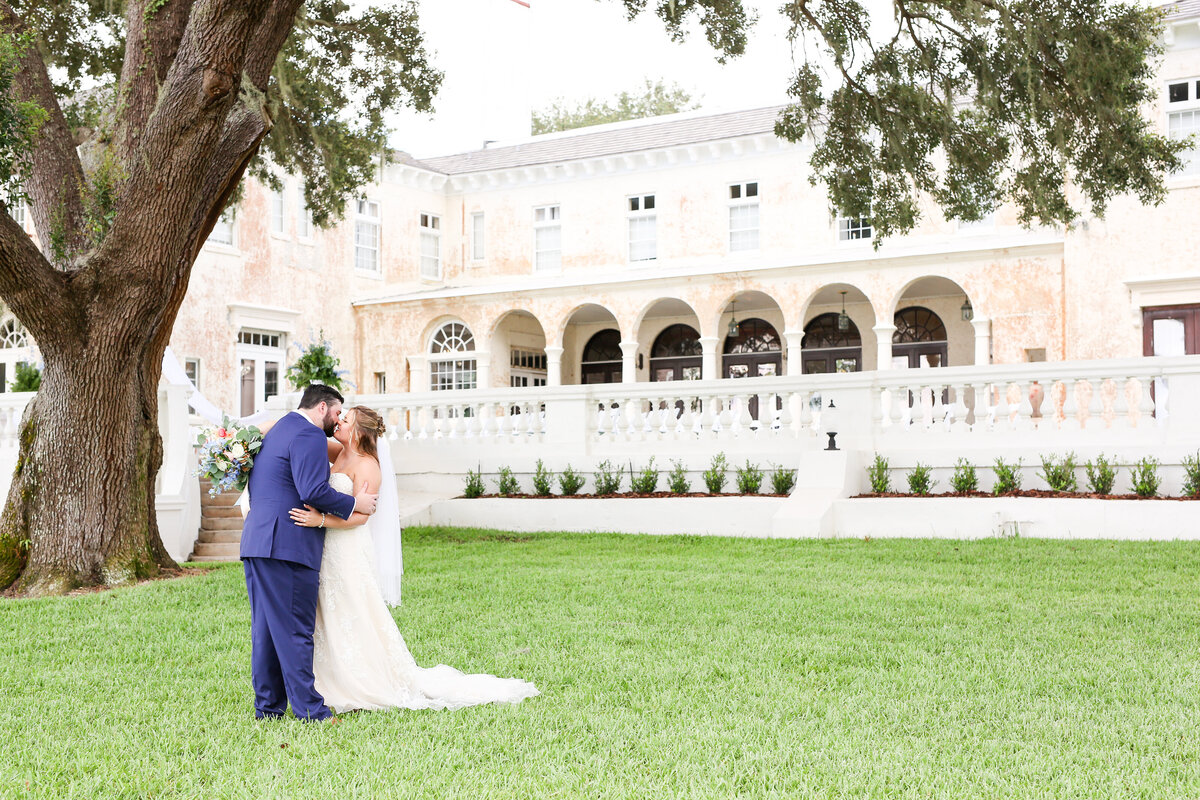 Bride and groom share kiss in front of Orlando Wedding Venue BellaCosa
