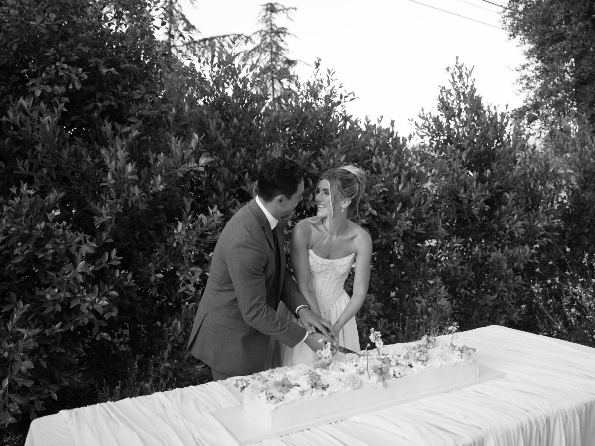 Couple cutting their wedding cake together, elegantly captured by a La Jolla wedding photographer.