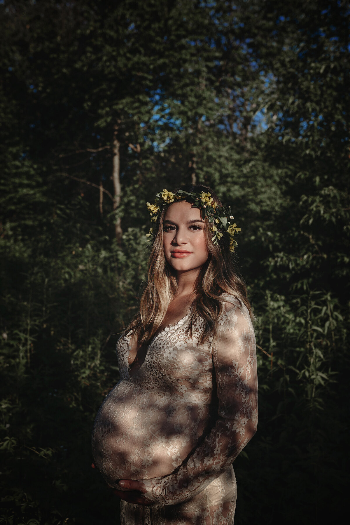 Maternity portrait in dappled light outside