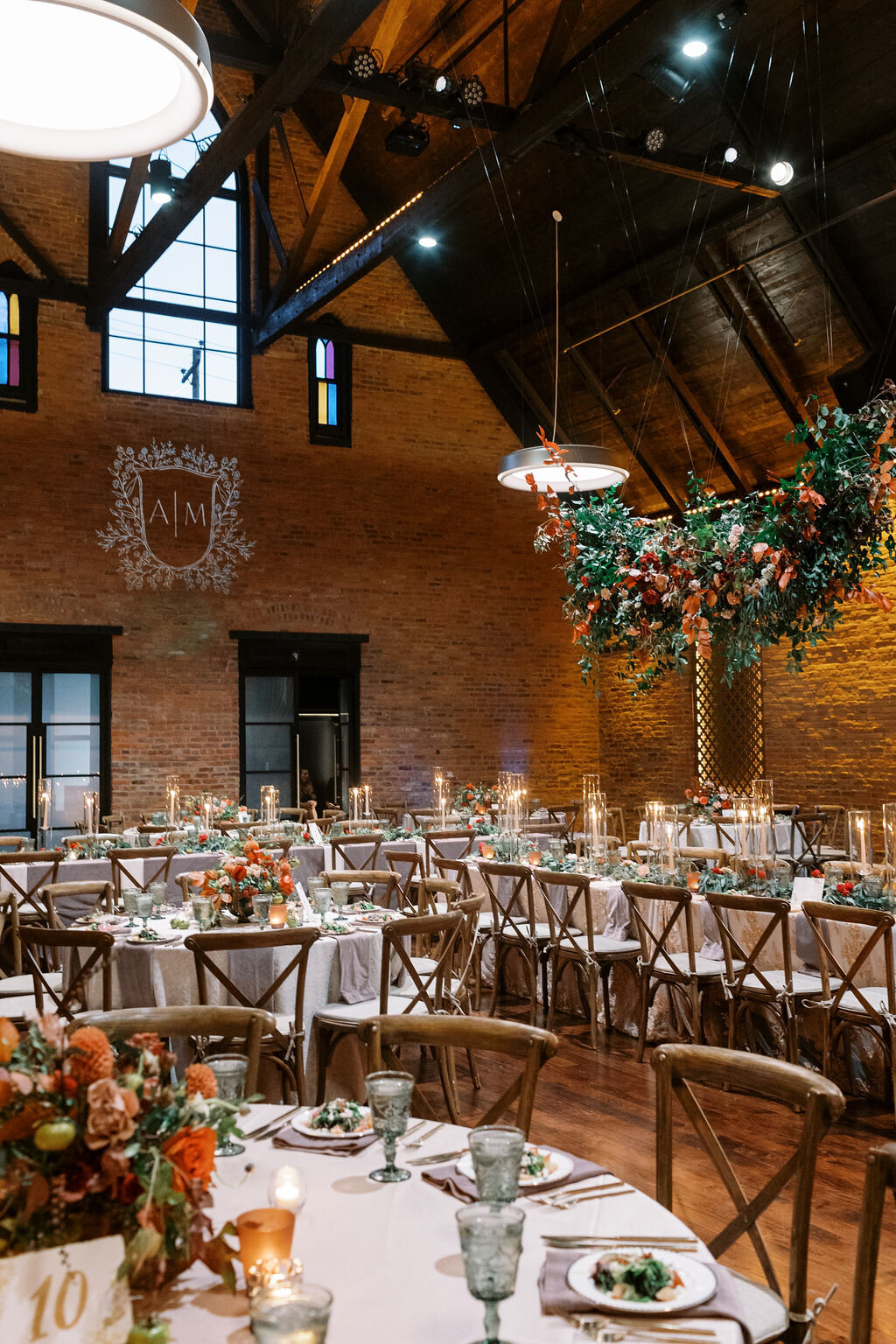 Gorgeous hanging installation of fall foliage, lush greenery and florals over the ceremony turned reception space enhancing the warm, natural atmosphere. Designed by Rosemary and Finch in Nashville, TN.