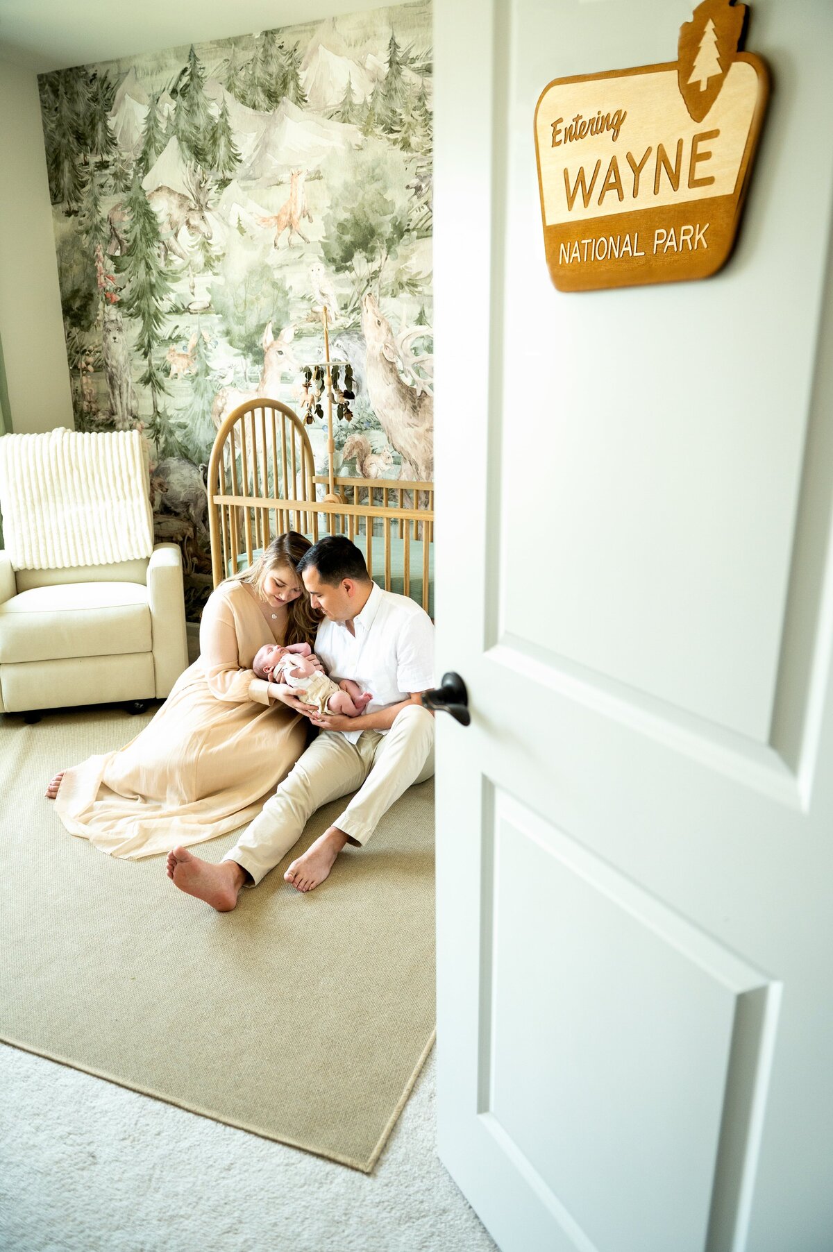 Woodland themed nursery with new parents in front of crib