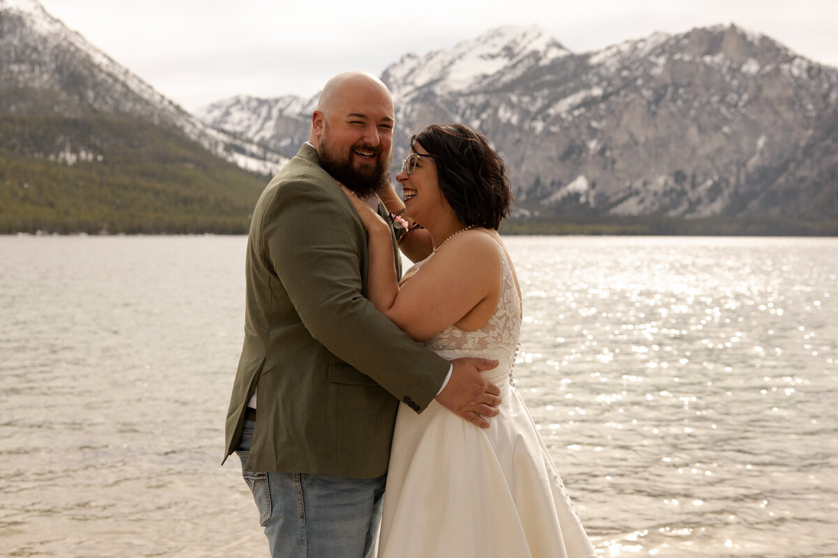 Bride and groom hugging by the lake smiling ring taken by idaho elopement photographer