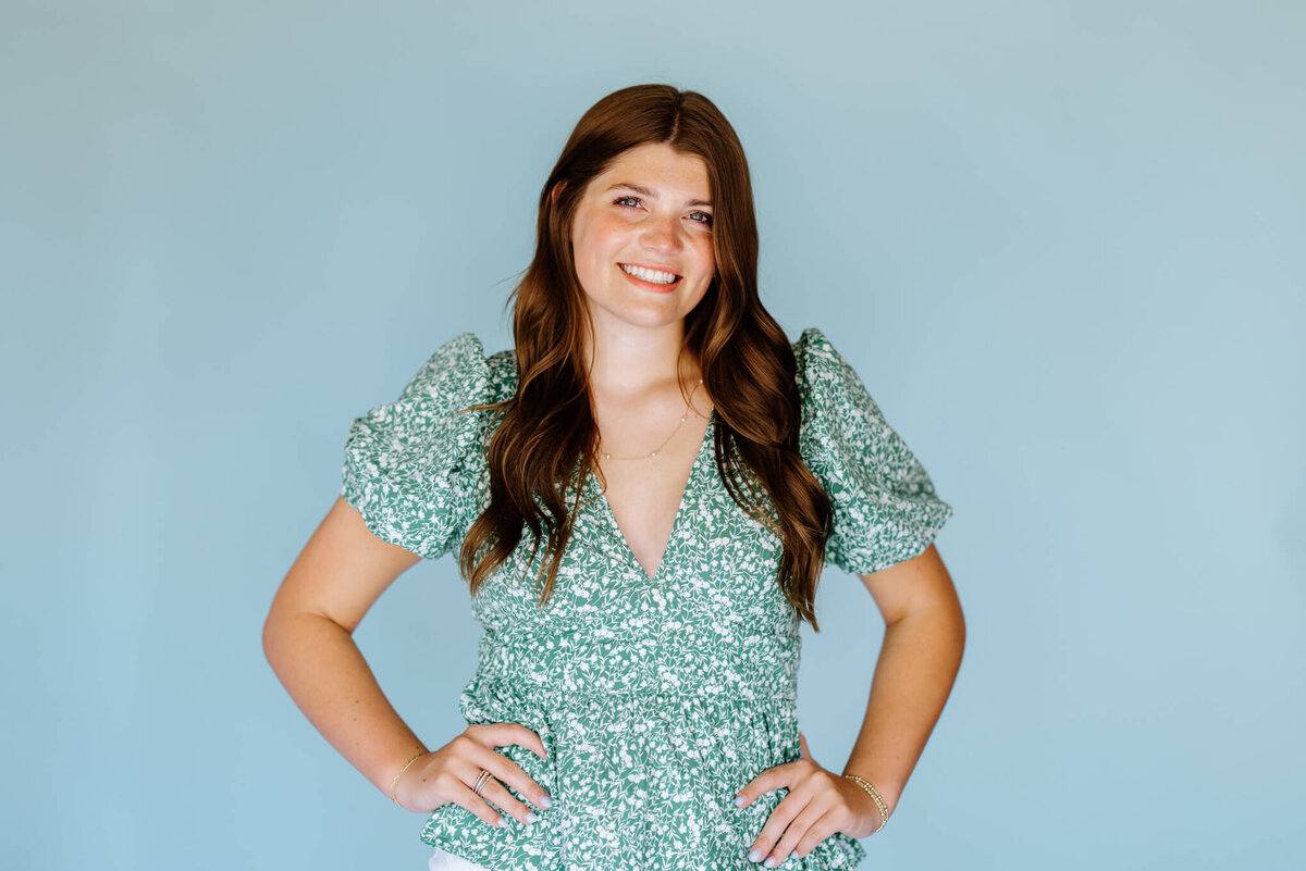 headshot portraits of 2023 college freshman in green floral top and light blue background