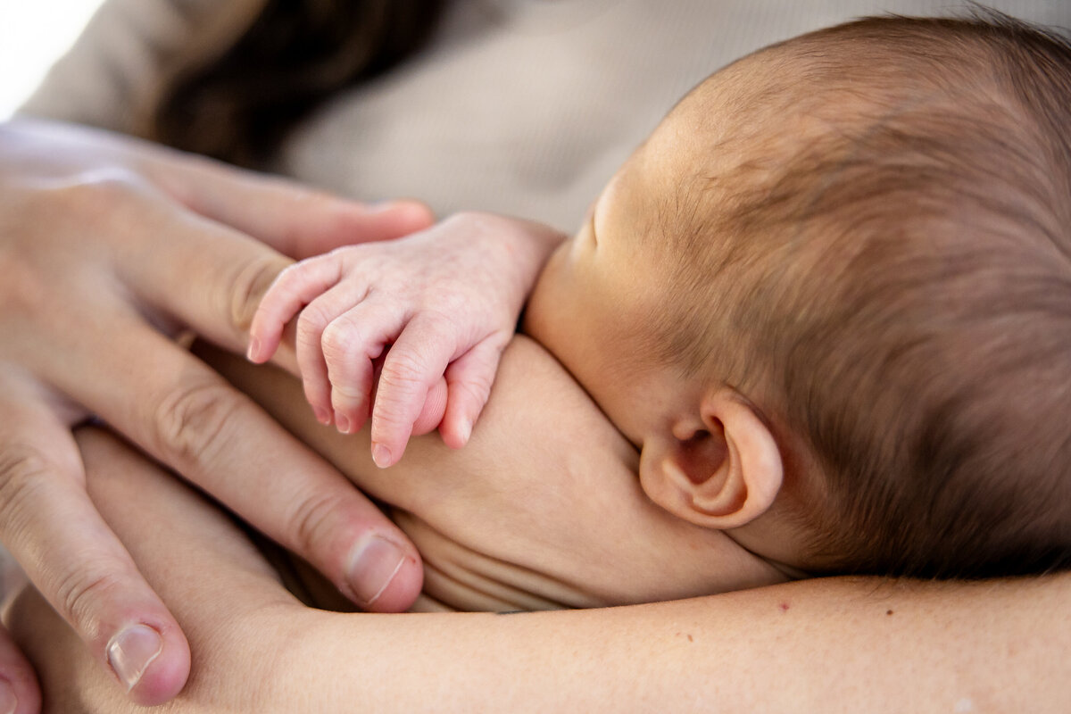 Baby holding onto mom's fingers