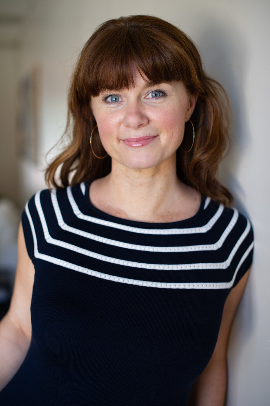 Professional headshot of Leona Laurie wearing black and white striped top for personal brand photography session.