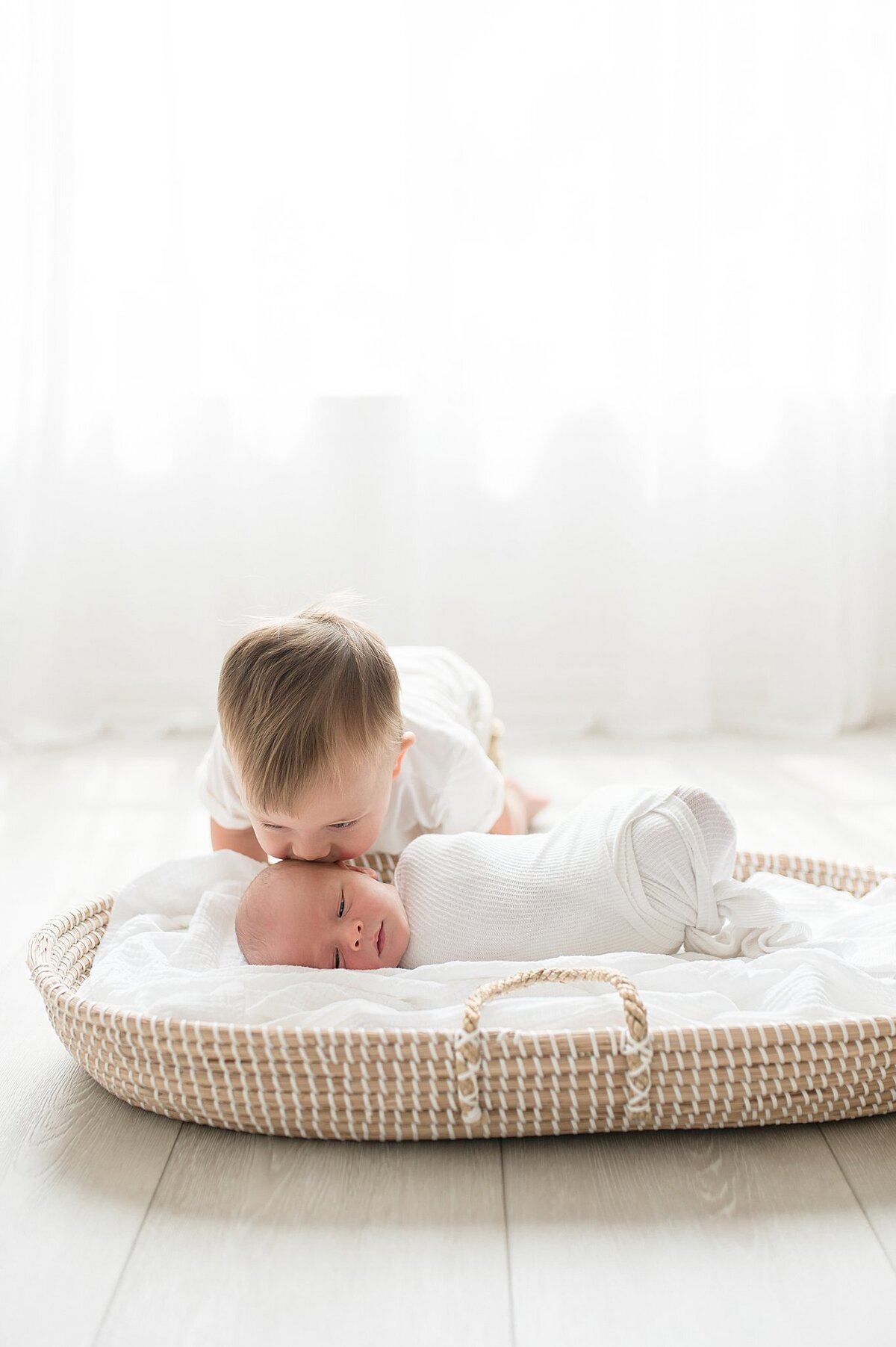 big brother and baby in bassinet in Frisco Newborn Photography photoshoot