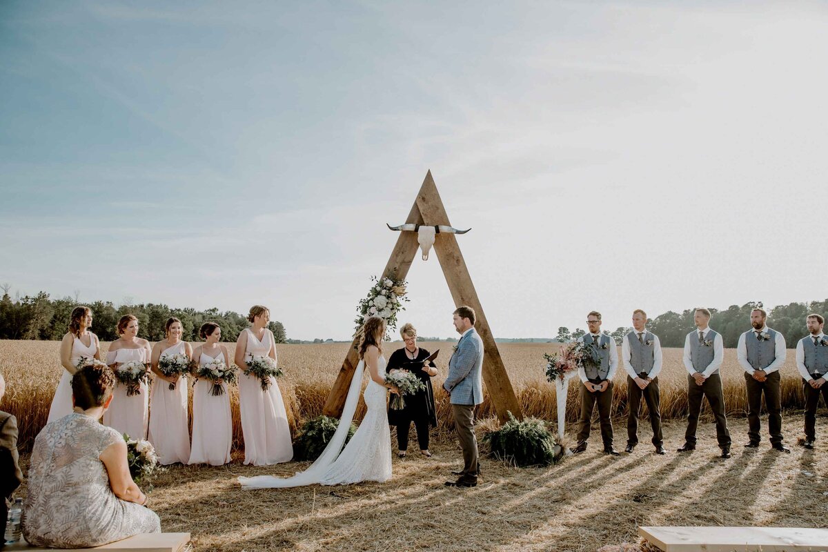 Bride and groom exchanging vows at an outdoor rustic farm wedding in Exeter, Ontario