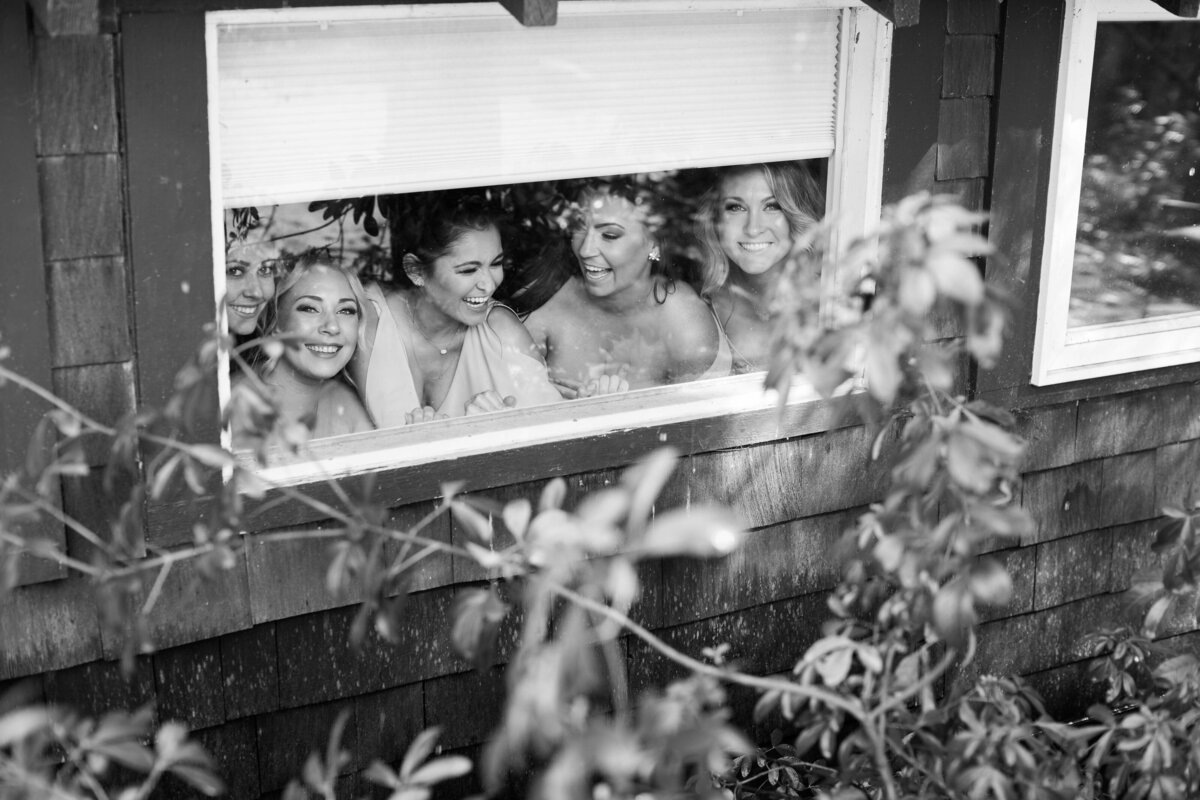 bridesmaids peaking trough a window