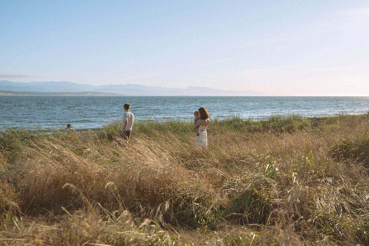 family of four walking towards open beach with two boys