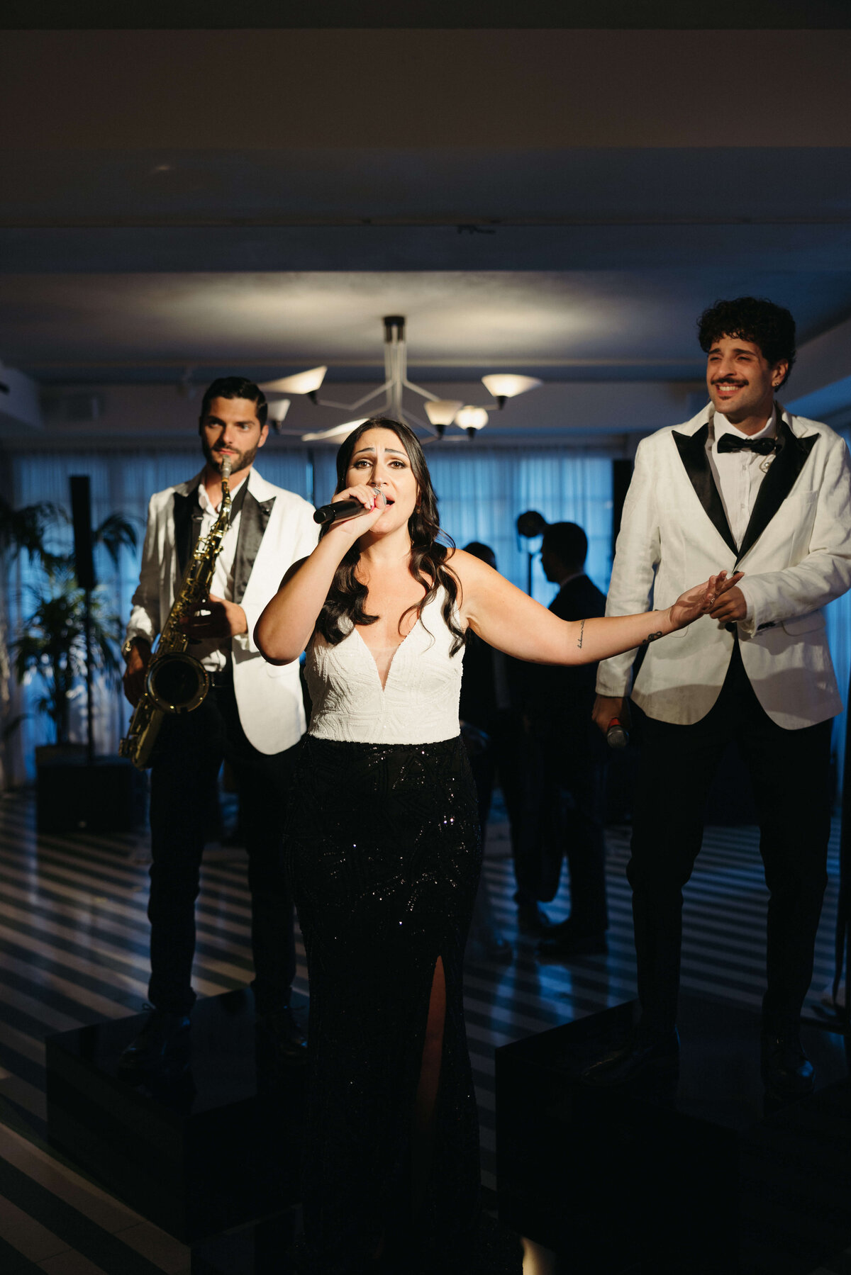 Lead singers performing at wedding reception with dramatic lighting

