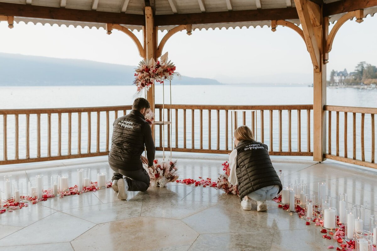 Typhaine et son assistant mettant en place le décor d'une demande en mariage organisée sous le kiosque du Palace de Menthon. La vue sur le lac d'Annecy est magnifique.