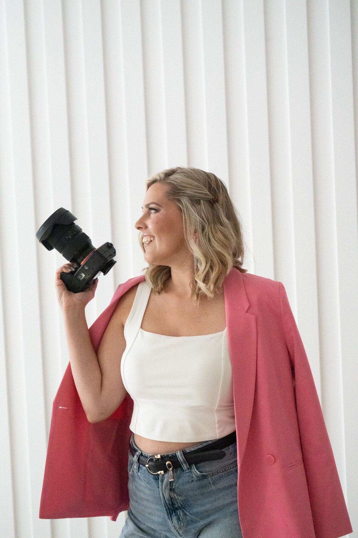 Woman holding a camera during a personal branding photography session in Fredericton