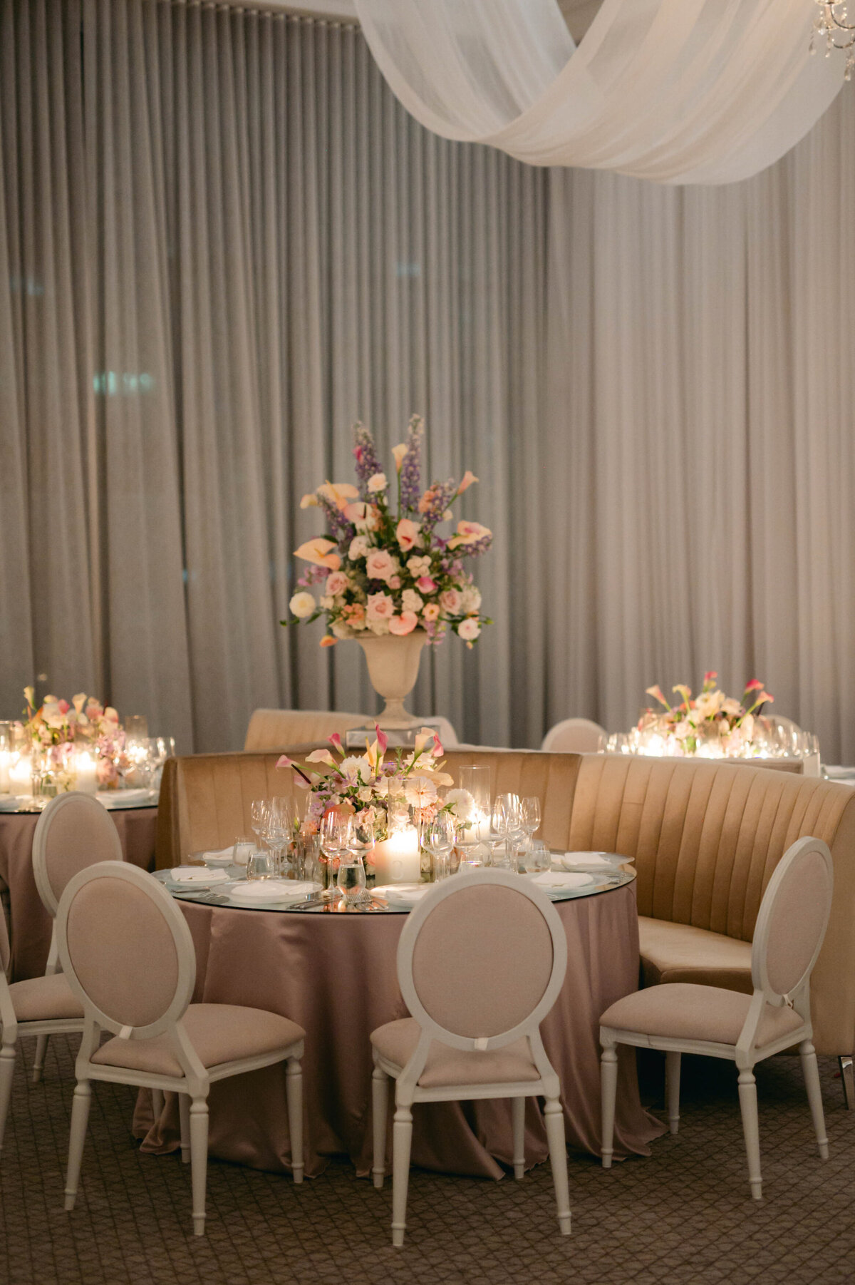 An elegant wedding reception at the Four Seasons featuring arrangements of colourful, pastel flowers.