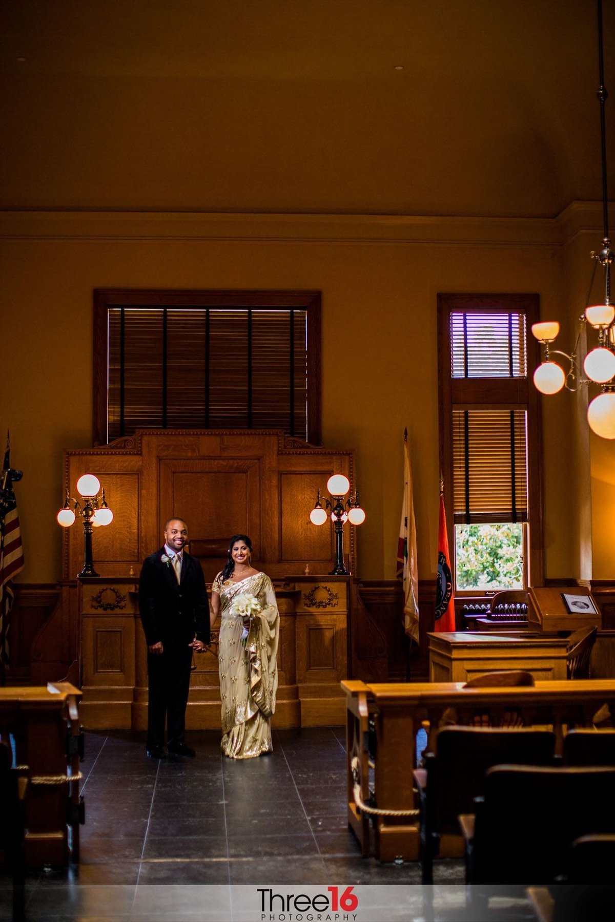 Newly married couple pose for photos in the courtroom