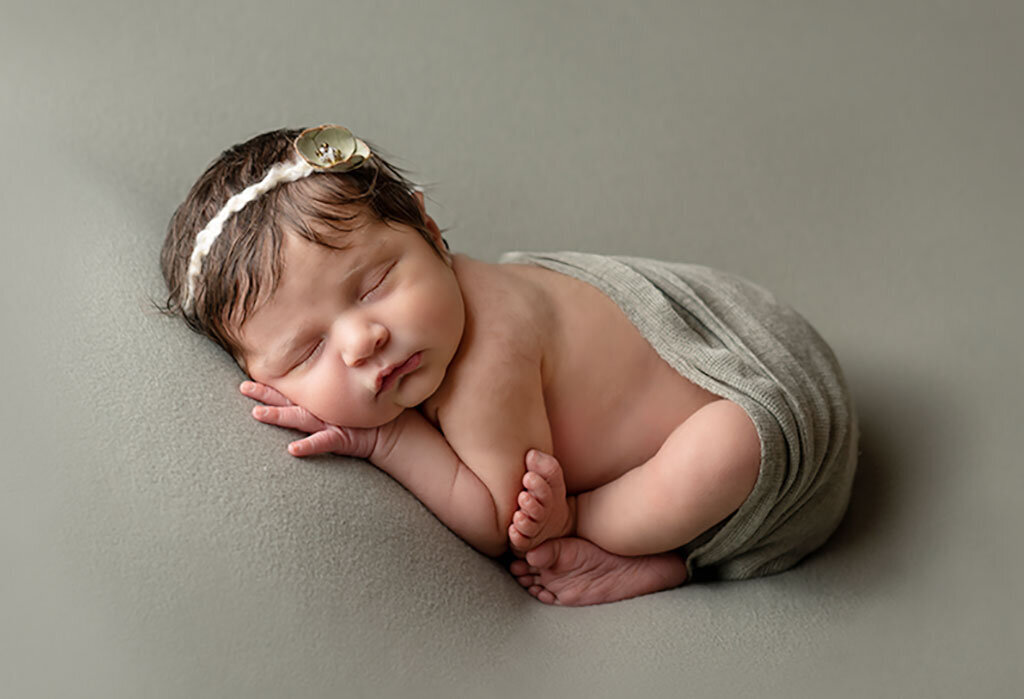 Newborn-girl-on-sage-green-backdrop-with-headband