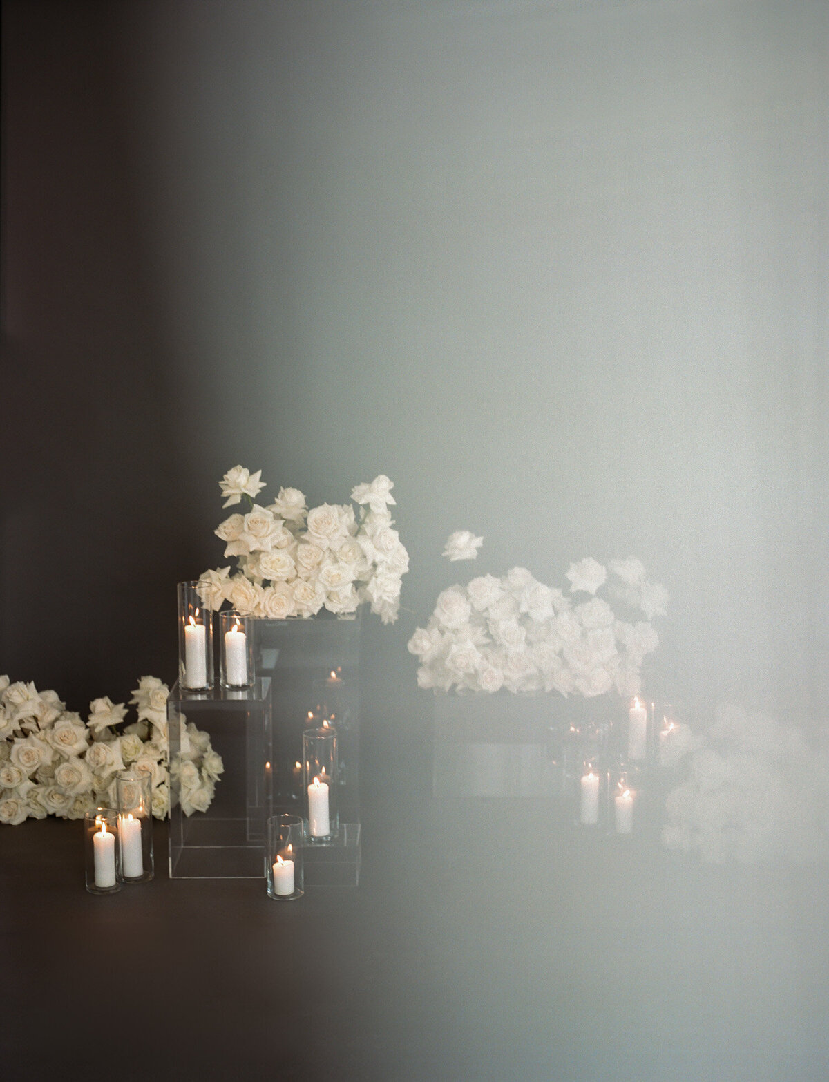 ethereal, otherworldly florist branding photo, white roses, candles, dark background, film