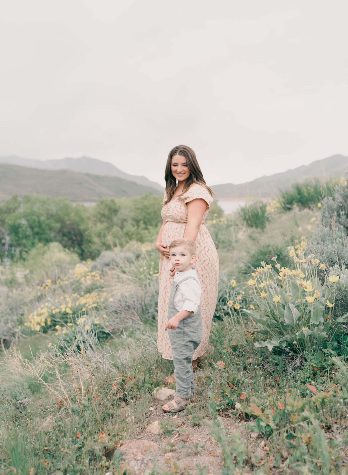 Peaceful mountain view with mom-to-be in neutral-toned dress. CAPTURED BY Newborn Photography Salt Lake City, Newborn Photographer Riverton, Maternity Photographer Salt Lake City.