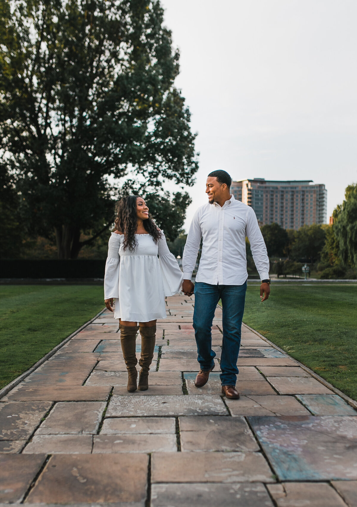 Woman and man hold hands and walk outside.