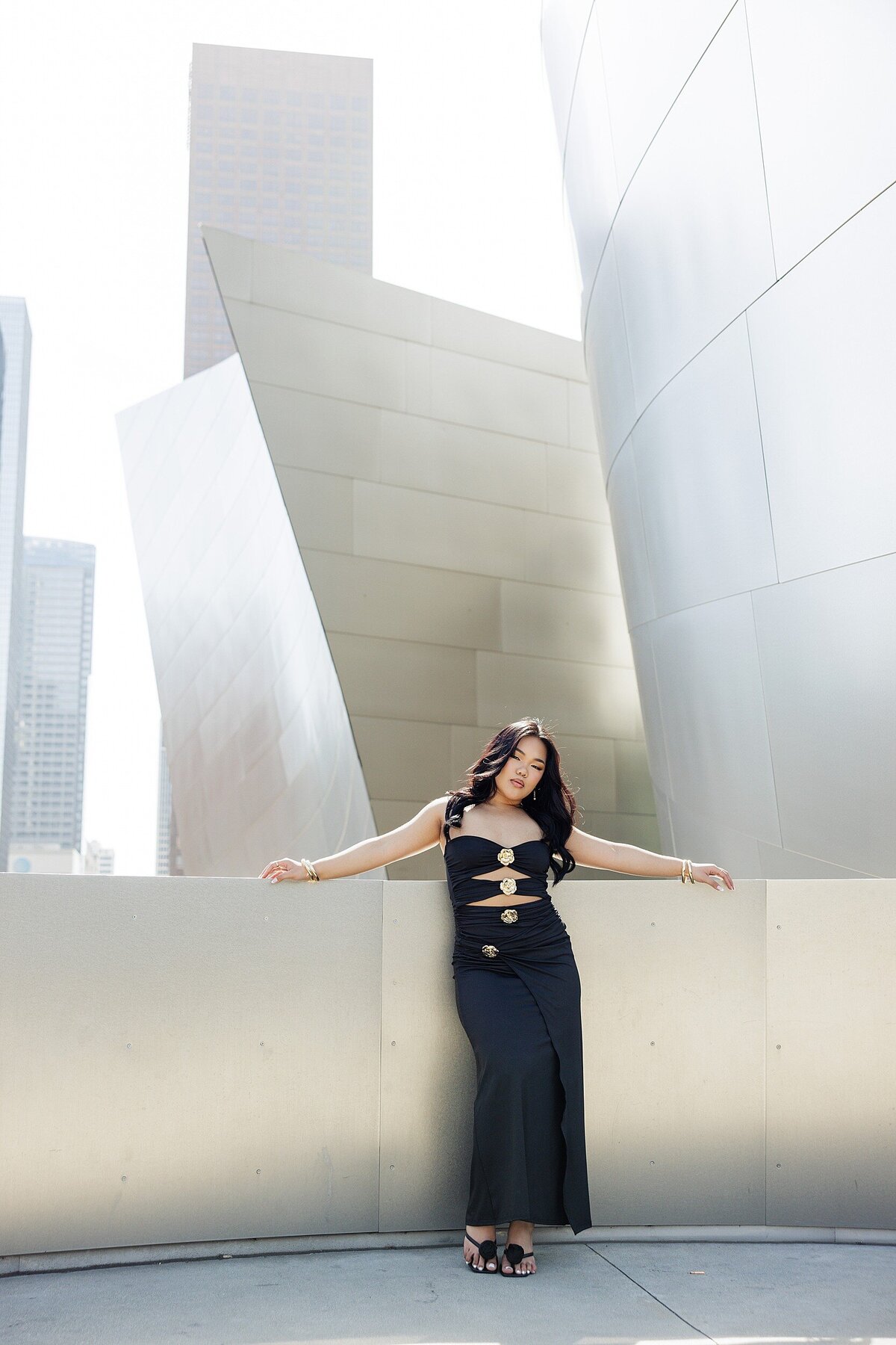 Sleek senior portrait of a high school teen in a black dress posing confidently at the Walt Disney Concert Hall in Downtown Los Angeles