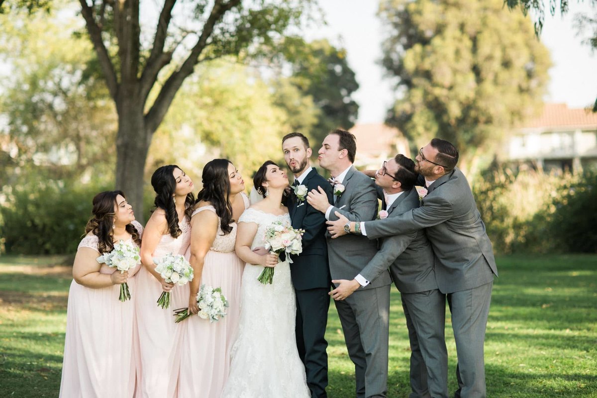 Bridal party makes kissy faces along with the Bride and Groom