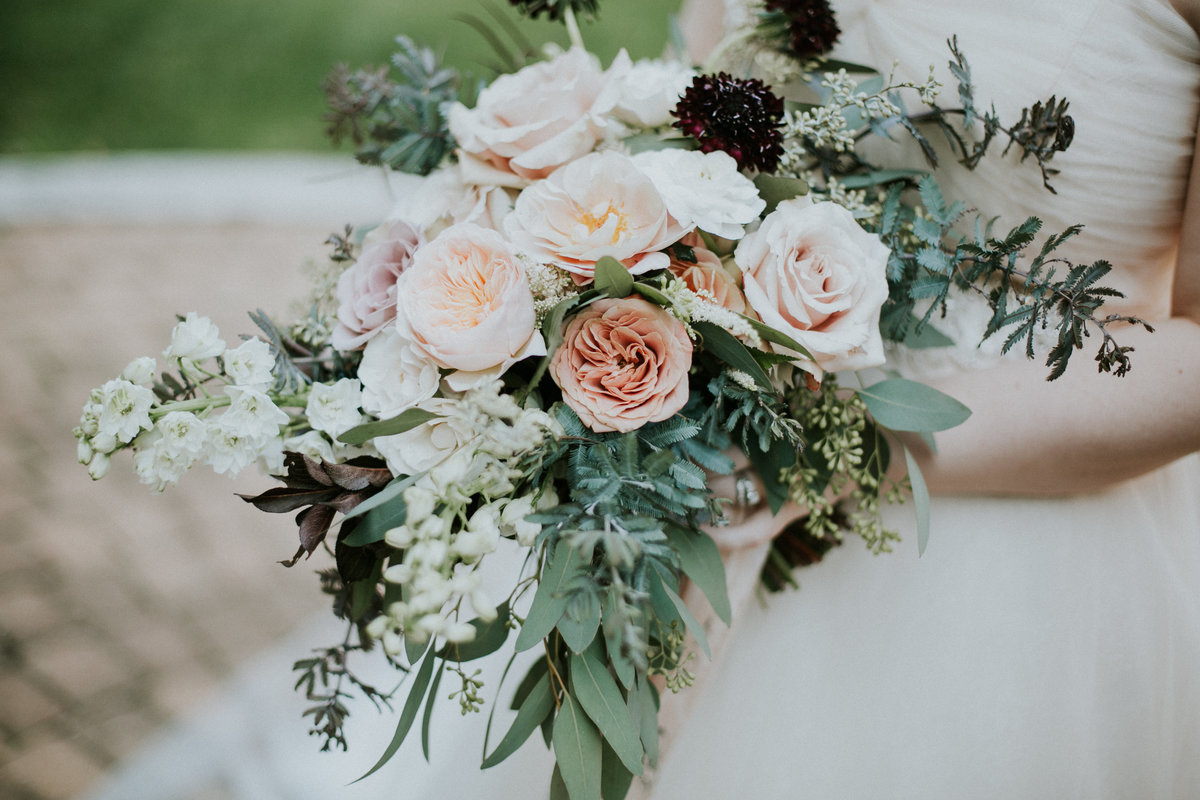 Bride holds purple blush and white bouquet by Meg Catherine Florals