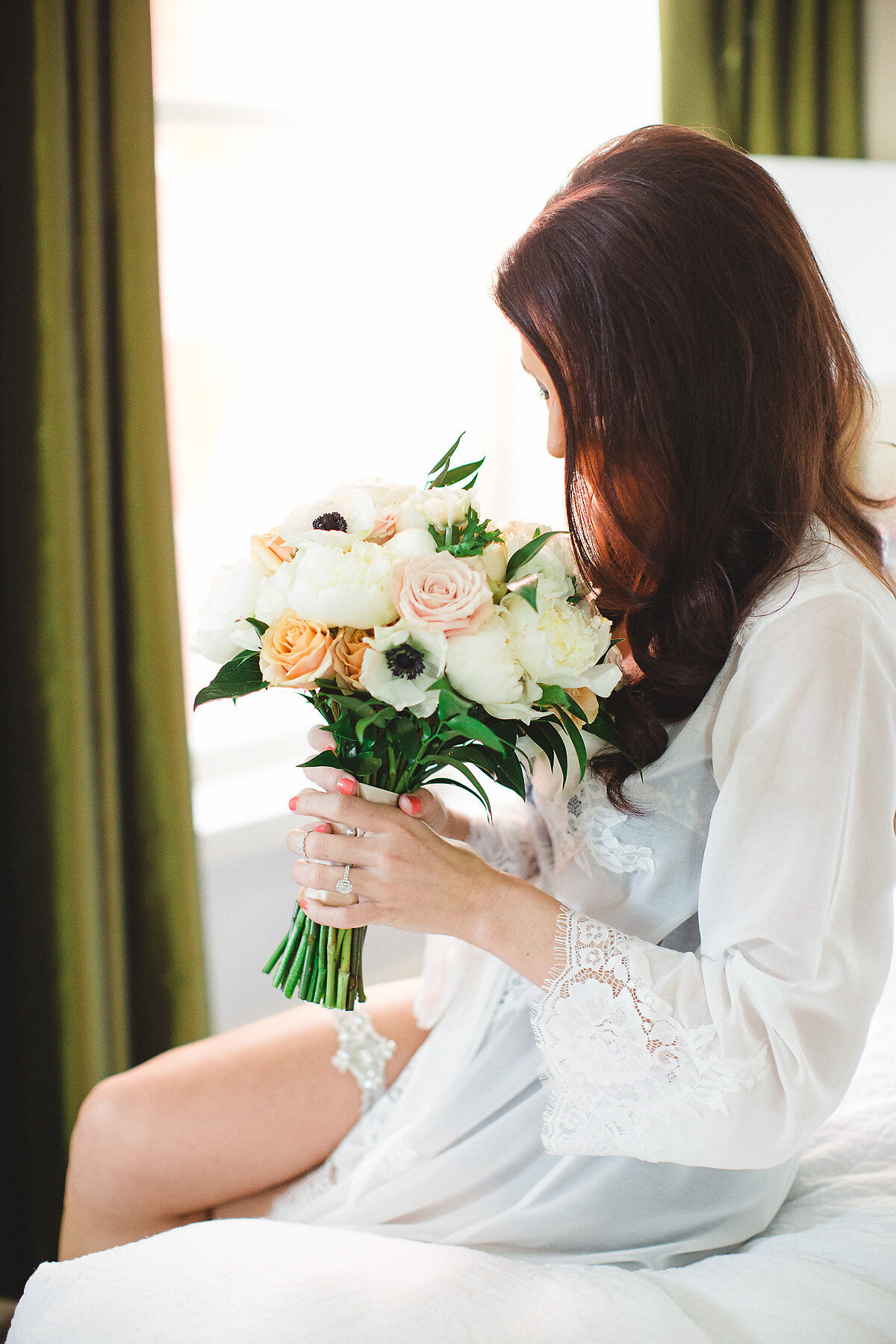 Bride in silk gown holding bouquet