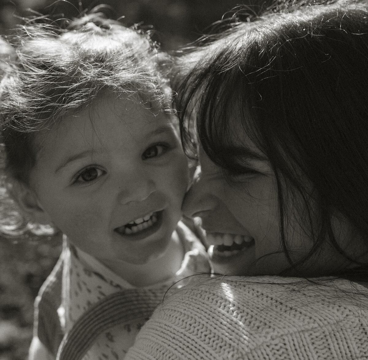 mother and daughter laughing and cuddled up during a photoshoot in Bend, Oregon