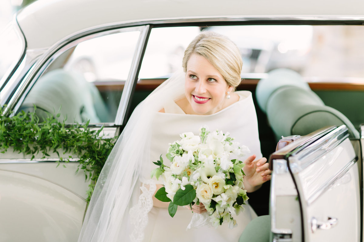 bride exiting vintage car with cascading bouquet