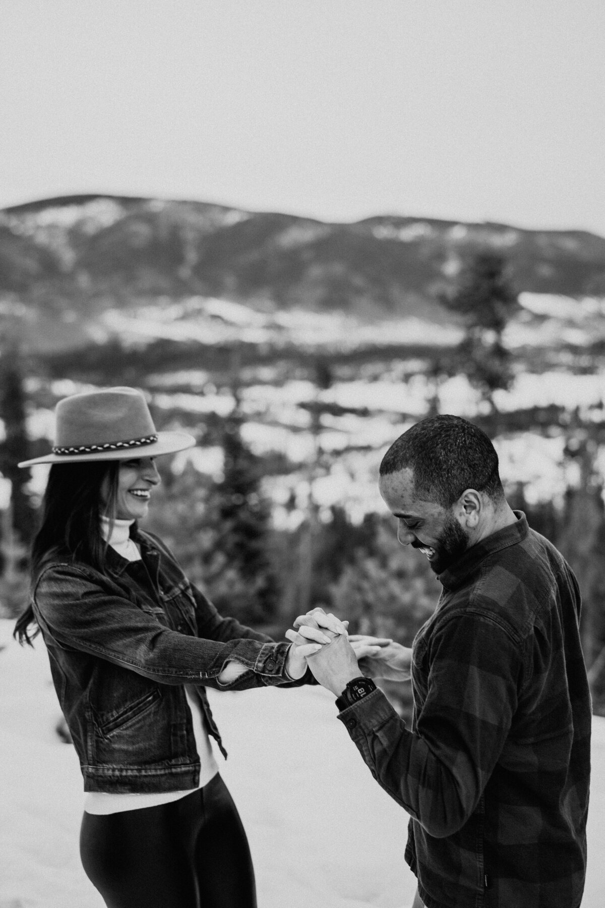Playful, blurred shot of couple spinning joyfully with Breckenridge mountain views.