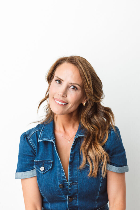 Girl in jean jumpsuit bites her lower lip.